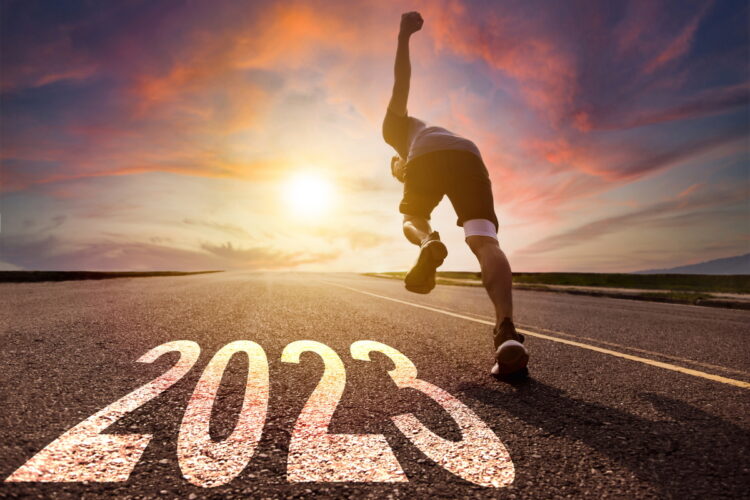 Young man running and sprinting on the road with 2023 in the foreground.